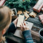 Woman planning holding a phone with a calendar on the screen working on christmas desk