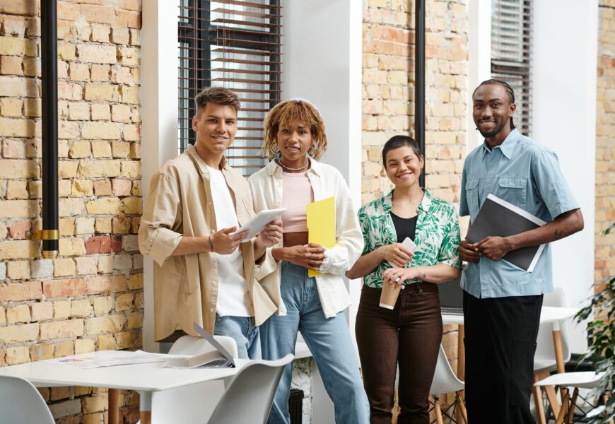 interracial business people looking at camera in office, coworking, folders, gadgets, generation z