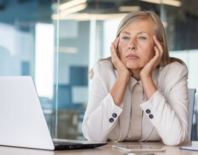 Sad unsatisfied senior woman at workplace depressed, mature business woman unhappy with achievement