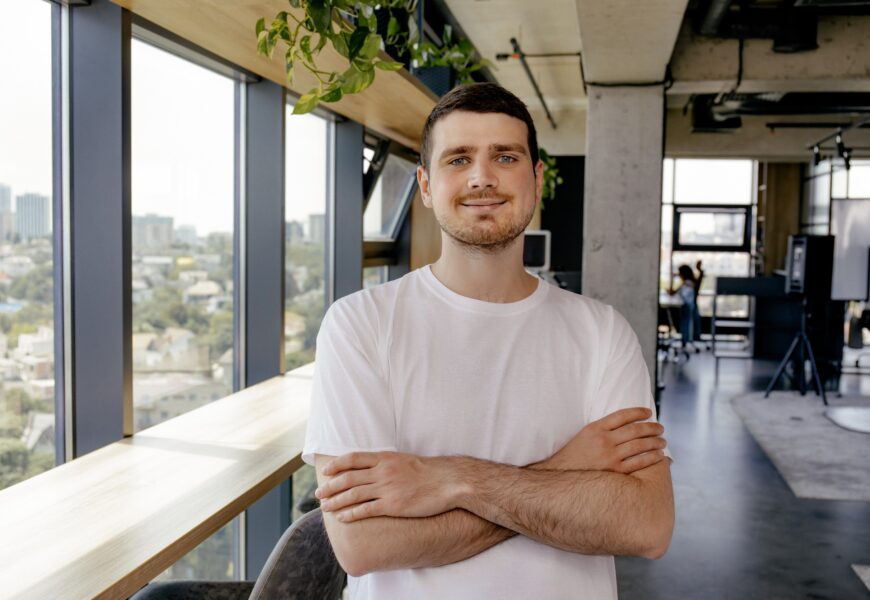 A cheerful young entrepreneur works in a modern workspace