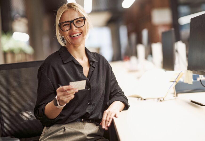 A Confident Businesswoman Smiling Brightly at Her Modern Office Desk Ready for Work and Success