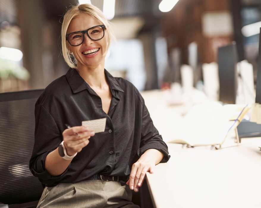 A Confident Businesswoman Smiling Brightly at Her Modern Office Desk Ready for Work and Success