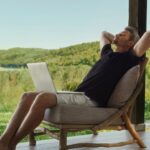 Man relaxing with laptop in nature. Work-life balance concept