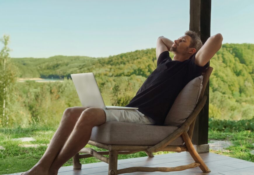 Man relaxing with laptop in nature. Work-life balance concept