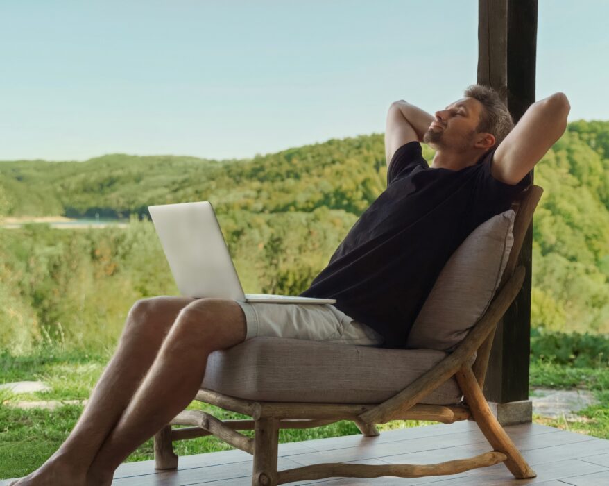 Man relaxing with laptop in nature. Work-life balance concept